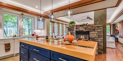 kitchen remodel includes stone fireplace and blue drawers under island JM Kitchen & Bath Design