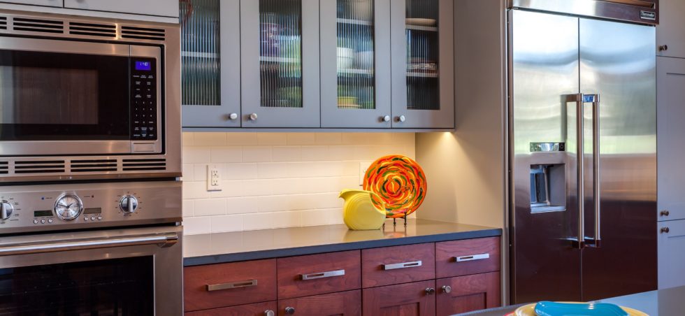 Stained wood cabinets paired with grey painted shaker style glass front cabinets