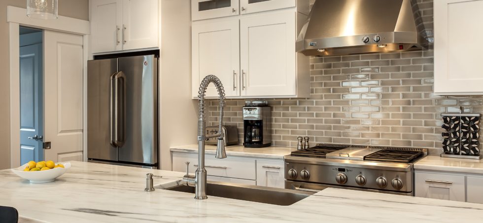 White kitchen cabinets with granite island