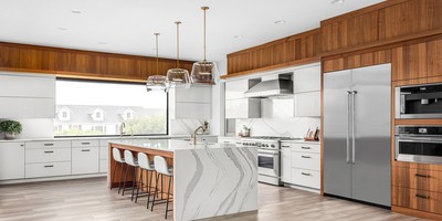 full view of kitchen remodel with large island that doubles as seating area along with wood and white cabinets JM Kitchen & Bath Design