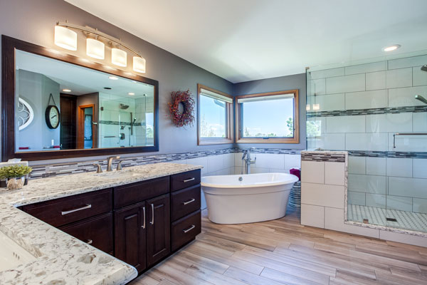 updated bathroom features soaking tub, extra countertop space and glass door shower JM Kitchen & Bath Design