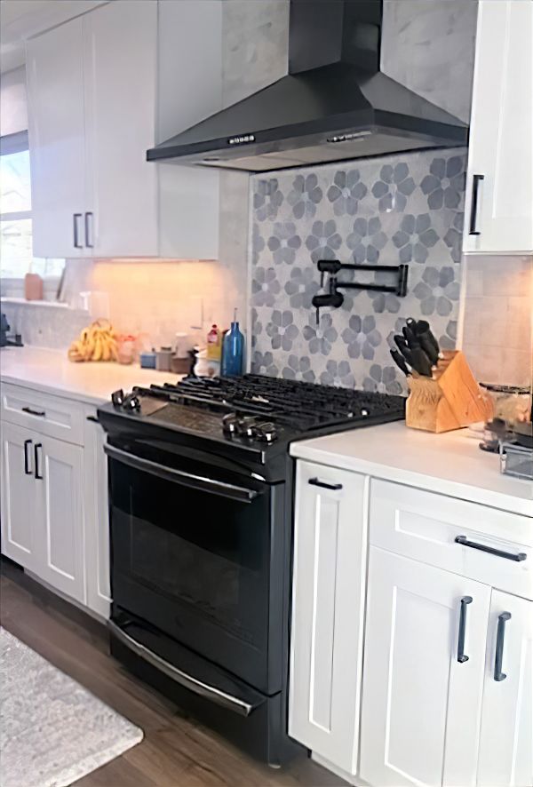 kitchen remodel features gray and white floral tile on wall behind stove JM Kitchen & Bath Design