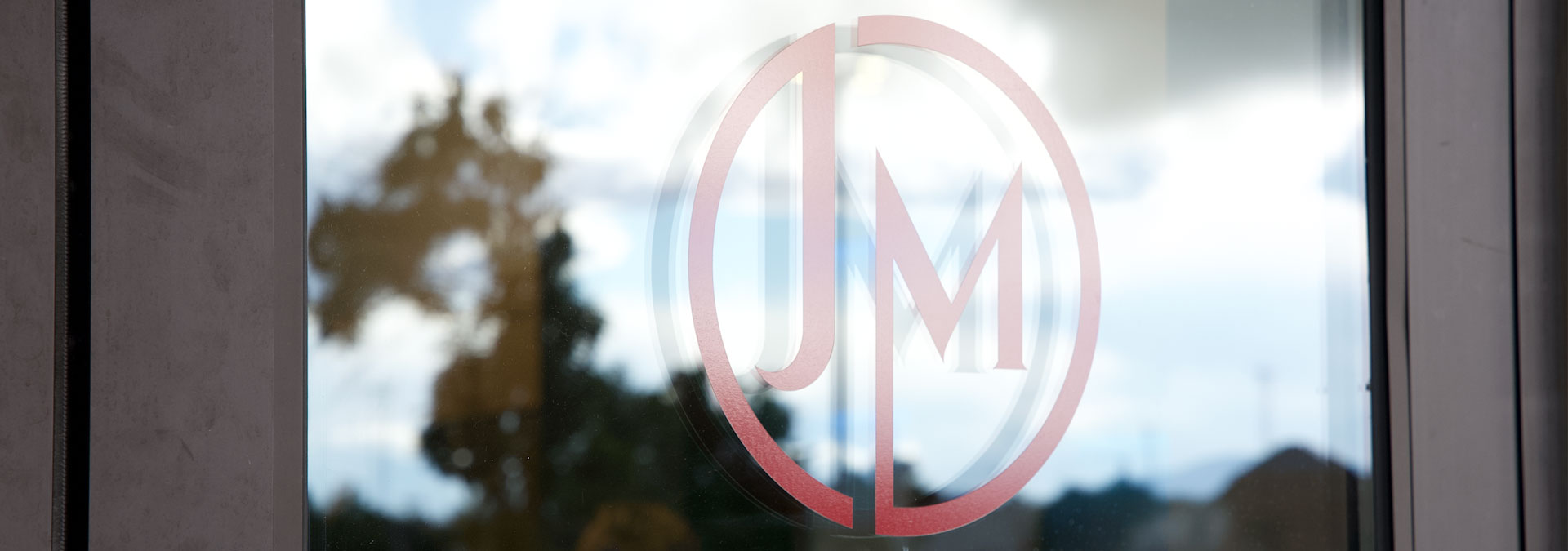 close up of JM Kitchen & Bath Design logo on showroom entry door