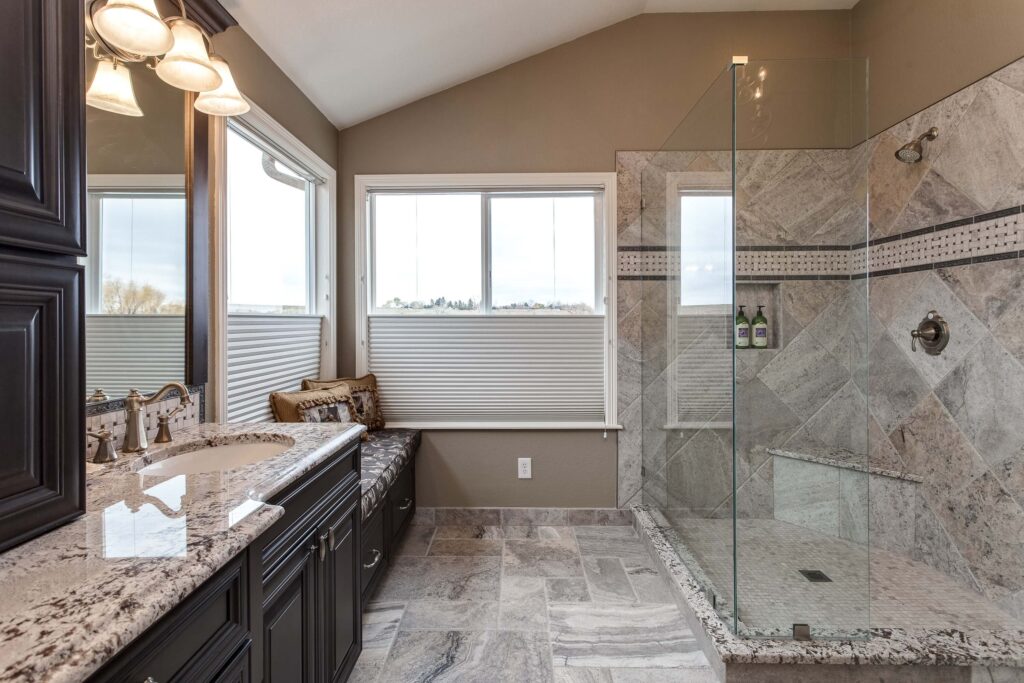 modern bathroom remodel features walk-in shower, bench seating, and granite vanity JM Kitchen & Bath Design