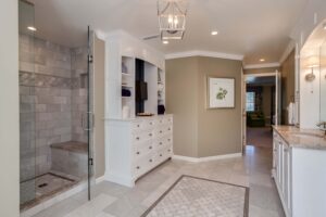 large walk-in shower with bench and plenty of storage space are features in this bathroom remodel from JM Kitchen & Bath Design