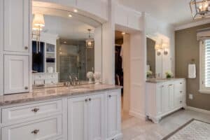 bathroom remodel from JM Kitchen & Bath Design features separate sinks and cabinet storage