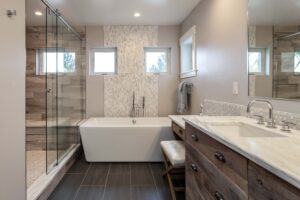 remodeled bathroom from JM Kitchen & Bath Design features freestanding tub, vanity, makeup vanity, and large shower with bench