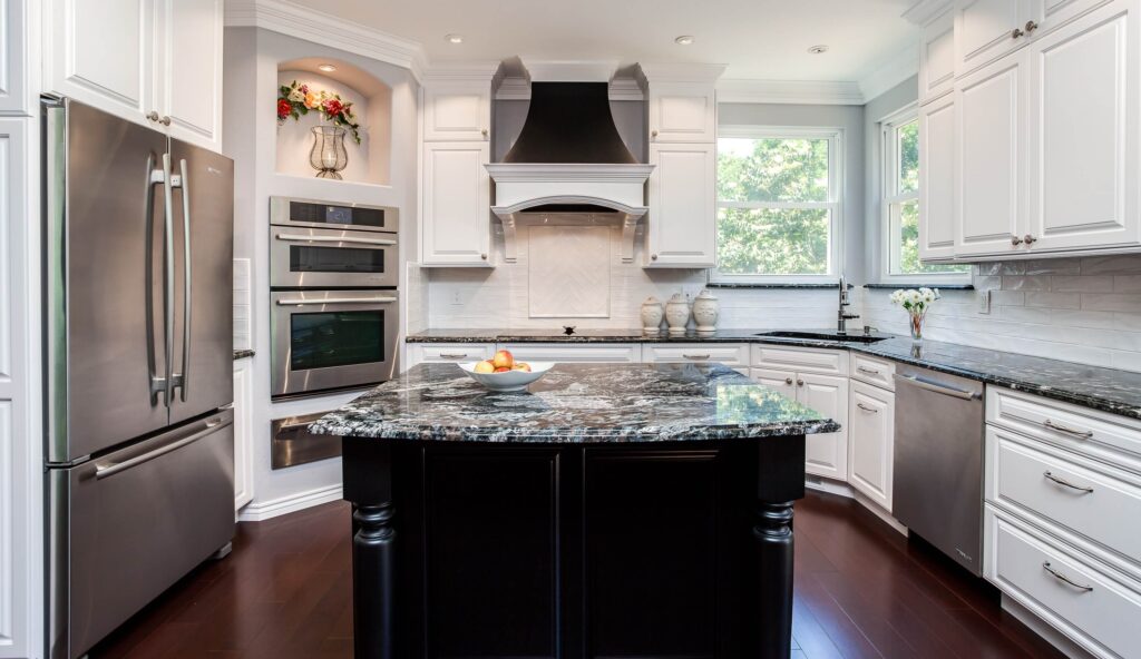 remodeled kitchen from JM Kitchen & Bath Design had several ovens, range top and large black island