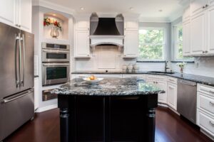 remodeled kitchen from JM Kitchen & Bath Design had several ovens, range top and large black island