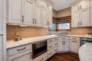 distressed cream cabinets are the feature of remodeled kitchen from JM Kitchen & Bath Design