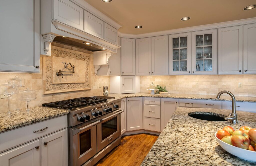 remodeled kitchen from JM Kitchen & Bath Design features sink in island, cream cabinets and lots of storage