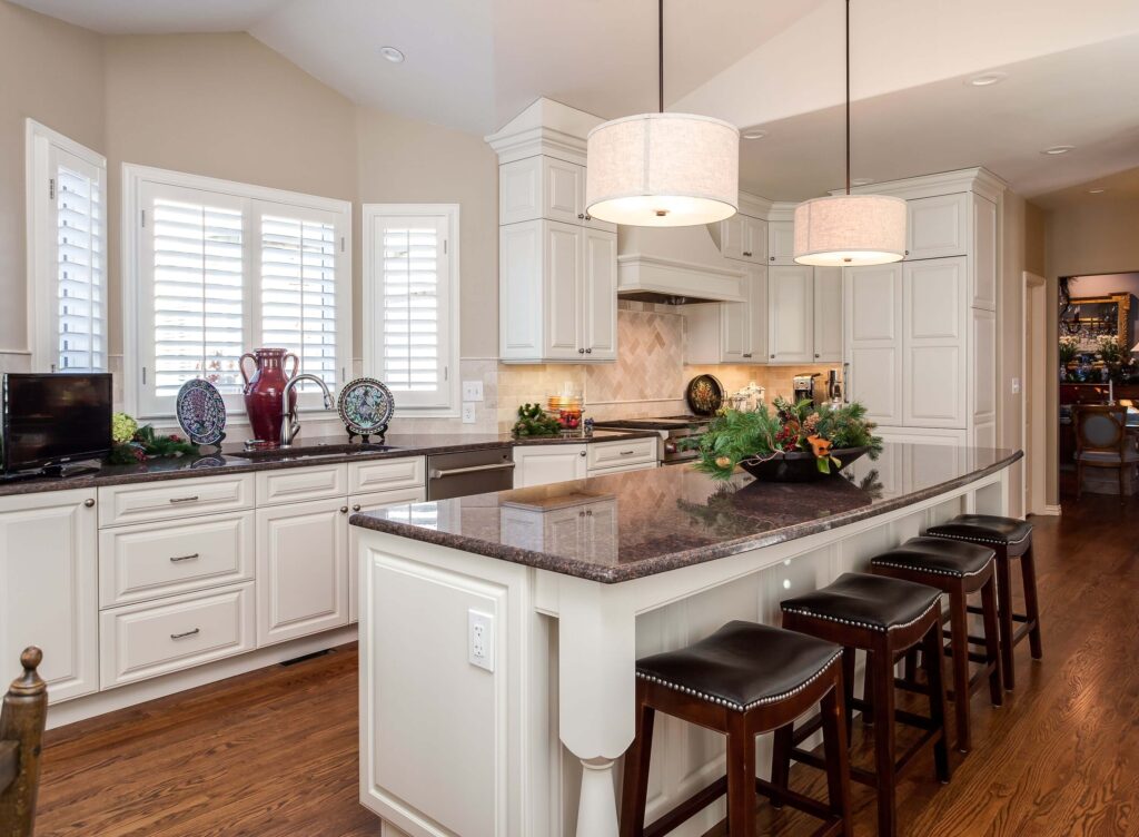 remodeled kitchen with farmhouse feel featuring white cabinets and lighting over island area JM Kitchen & Bath Design