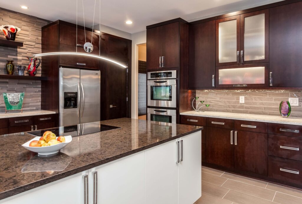 modern kitchen from JM Kitchen & Bath Design features cooktop on island and modern lighting