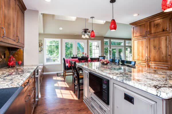 custom kitchen remodel features distressed gray cabinets, low microwave, and granite countertops JM Kitchen & Bath Design