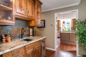 remodeled bar with granite countertop and unique copper tile accent JM Kitchen & Bath Design