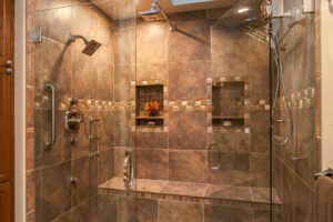 bathroom remodel features two skylights, dual shower heads, large bench, and cove for shampoo, soap, and other essentials JM Kitchen & Bath Design