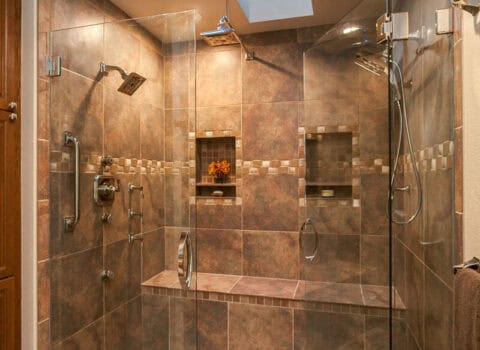 bathroom remodel features two skylights, dual shower heads, large bench, and cove for shampoo, soap, and other essentials JM Kitchen & Bath Design