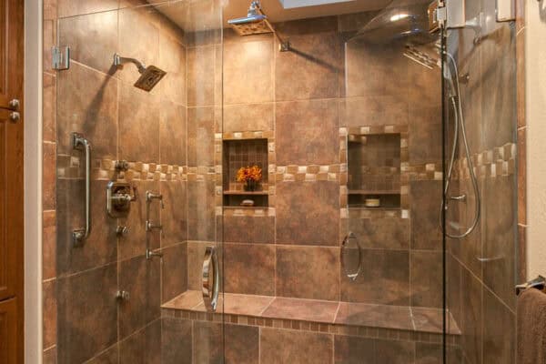 bathroom remodel features two skylights, dual shower heads, large bench, and cove for shampoo, soap, and other essentials JM Kitchen & Bath Design