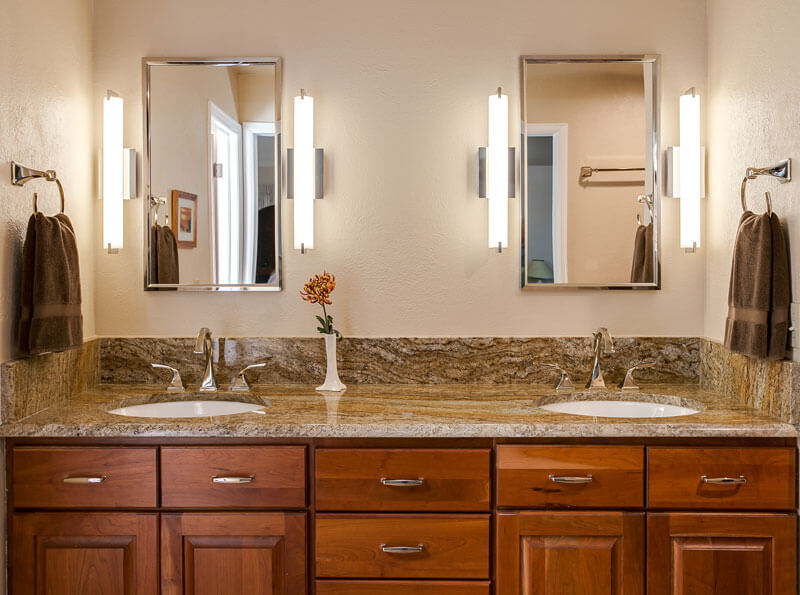 view of double vanity, two mirrors, and modern vertical light fixtures with cabinet space in remodeled bathroom JM Kitchen & Bath Design