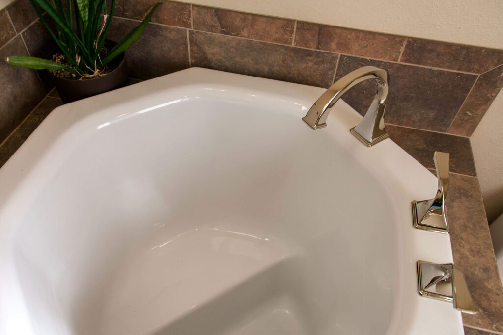 view from top of white soaking tub with chrome faucet in remodeled bathroom JM Kitchen & Bath Design