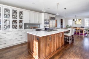 large white cabinets with glass display are featured in kitchen remodel JM Kitchen & Bath Design