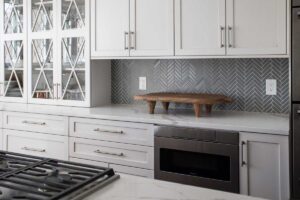 gray herringbone tile is featured in kitchen remodel JM Kitchen & Bath Design