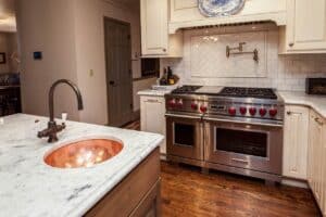 kitchen remodel with country finishes features Wolf appliance and copper pot faucet JM Kitchen & Bath Design