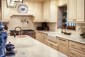 country kitchen has off white cabinets, apron sink, subway tile and large island JM Kitchen & Bath Design