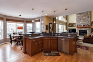 open concept kitchen with modern finishes including bar seating area unique ball lighting and wood floors JM Kitchen & Bath Design