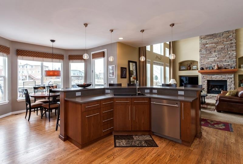 open concept kitchen with modern finishes including bar seating area unique ball lighting and wood floors JM Kitchen & Bath Design