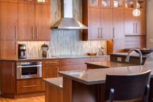 glass backsplash and long cabinet hardware create a modern vibe to remodeled kitchen JM Kitchen & Bath Design