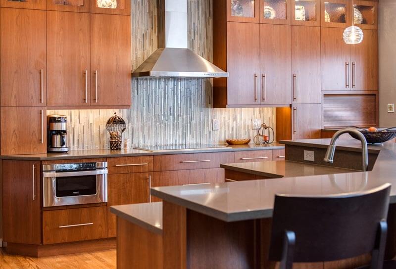 glass backsplash and long cabinet hardware create a modern vibe to remodeled kitchen JM Kitchen & Bath Design