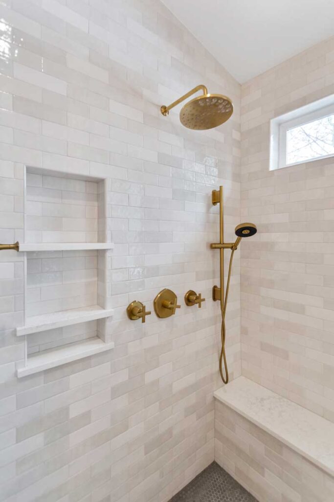 updated shower showcases matte brass finishes and light gray tile JM Kitchen & Bath Design