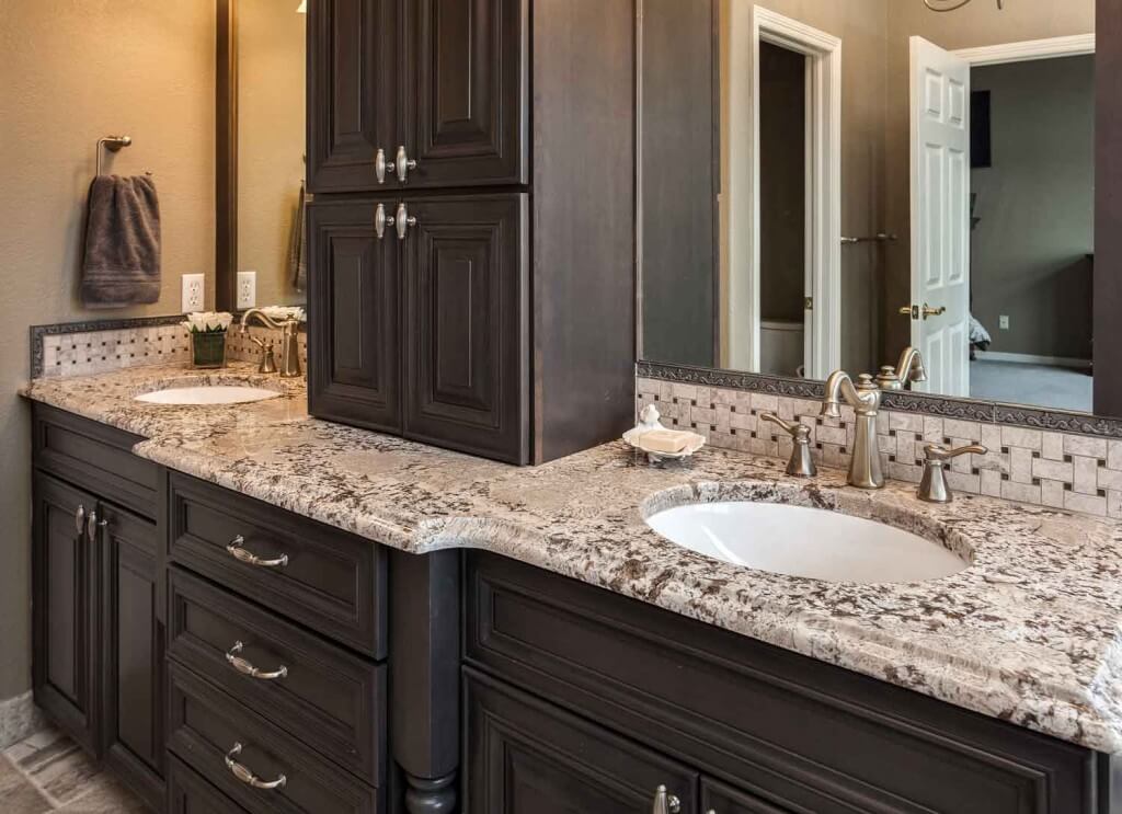 dark gray cabinetry finish and dual vanity with gray accents are features in remodeled bathroom by JM Kitchen & Bath Design