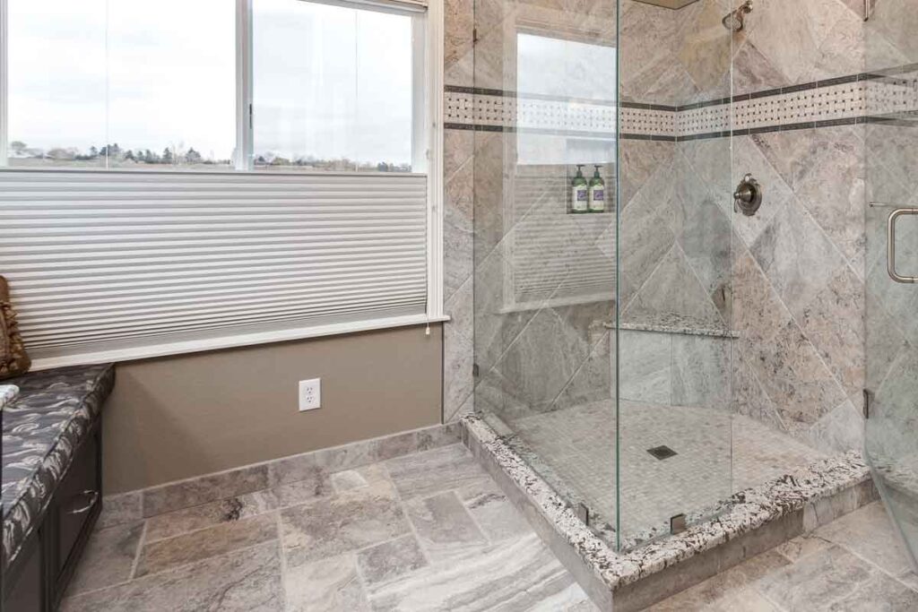 walk-in shower with bench and privacy blinds are features in newly remodeled bathroom JM Kitchen & Bath Design