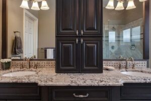 bathroom with dual vanity and linen storage in the middle are features of newly remodeled bathroom JM Kitchen & Bath Design