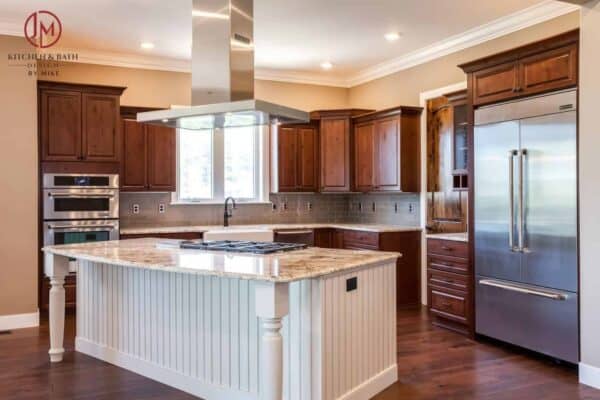 modern and farmhouse feel kitchen remodel with white island and darker wood cabinets JM Kitchen & Bath Design