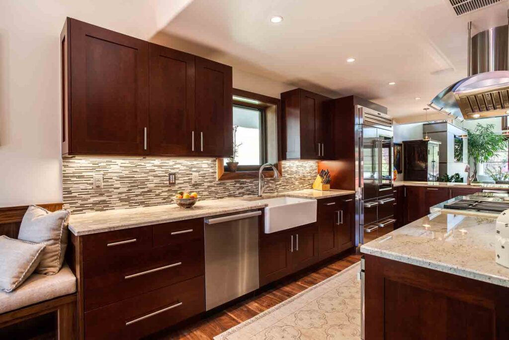 modern kitchen remodel from JM Kitchen & Bath Design features cherry wood cabinets, chrome hardware, and apron sink