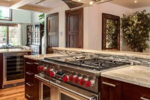 kitchen remodel features Wolf appliances and large, modern hood JM Kitchen & Bath Design