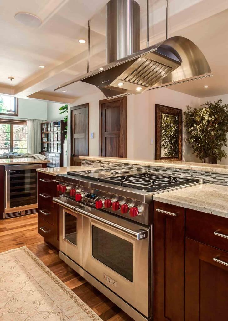 kitchen remodel features Wolf appliances and large, modern hood JM Kitchen & Bath Design