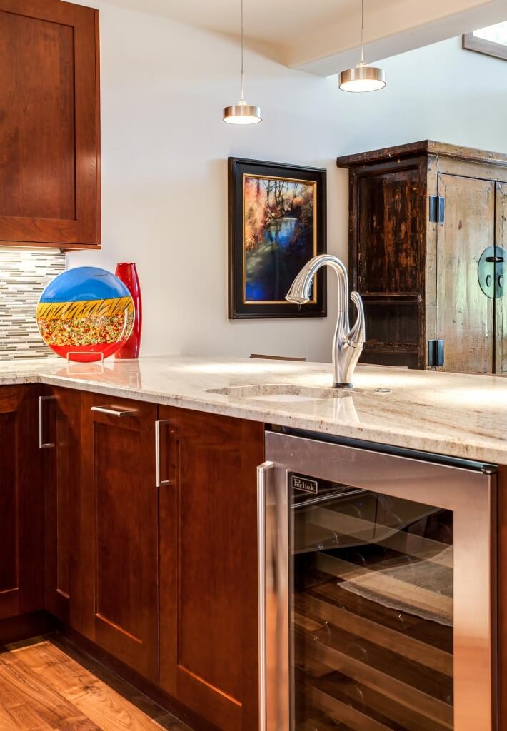 remodeled kitchen has modern lighting over bar area with wine cooler JM Kitchen & Bath Design