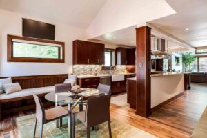 remodeled kitchen by JM Kitchen & Bath Design features bench seating area, bar island, and cherry wood finishes