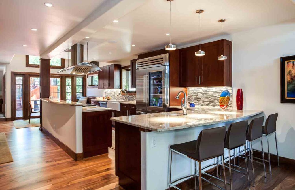 kitchen remodel features seating area, island with modern appliances, and updated lighting JM Kitchen & Bath Design