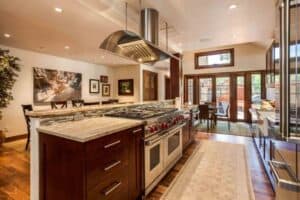 full view of modern kitchen remodel with dark cabinets, new appliances, large refrigerator and bar seating area JM Kitchen & Bath Design