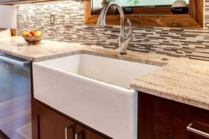 apron sink and new backsplash are a few of the remodel features in this new kitchen JM Kitchen & Bath Design