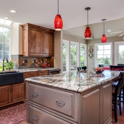 Natural wood cabinets with red glass lighting fixtures JM Kitchen & Bath Design