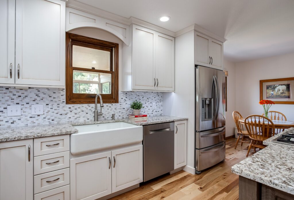 White painted cabinets with granite countertops and farmhouse or skirt sink