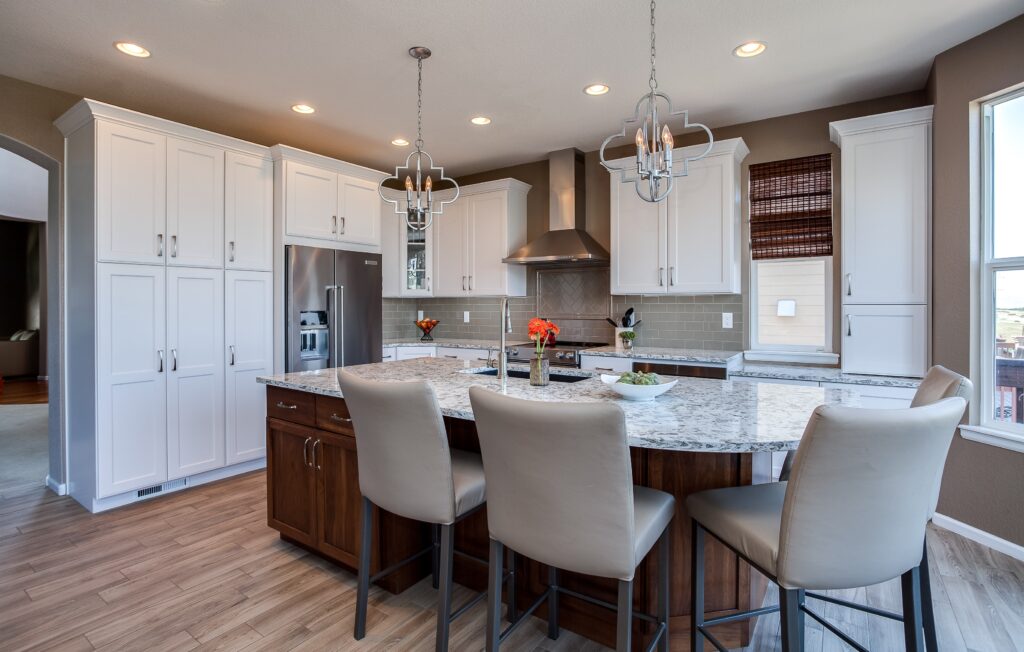 White painted kitchen cabinets with chandeliers over island