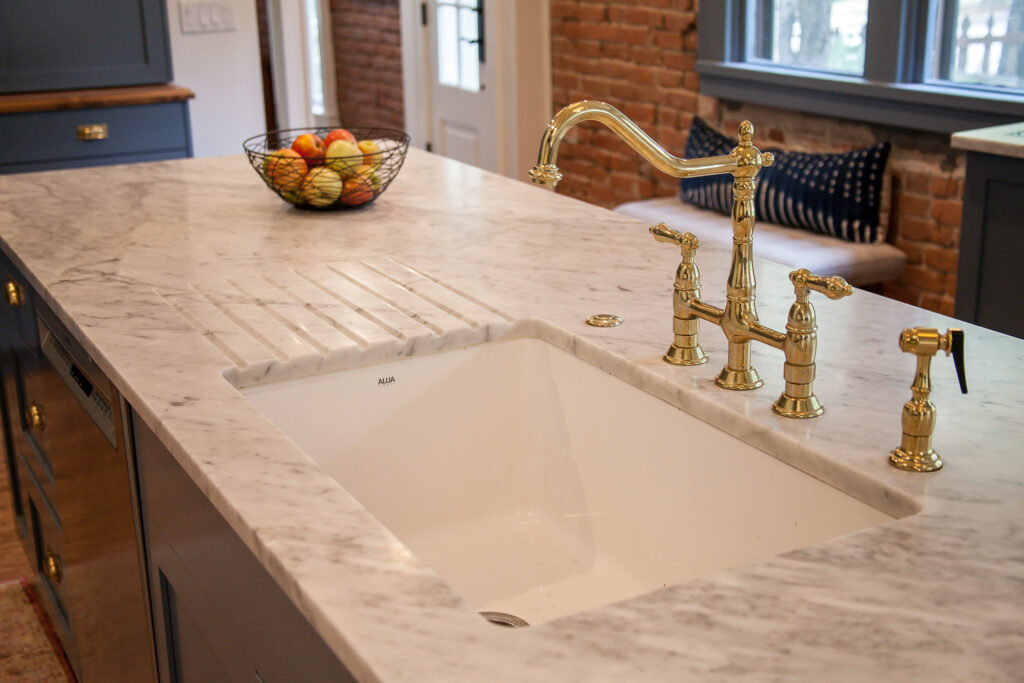 drainboard cut into the marble countertop at the sink for quick and easy cleanup