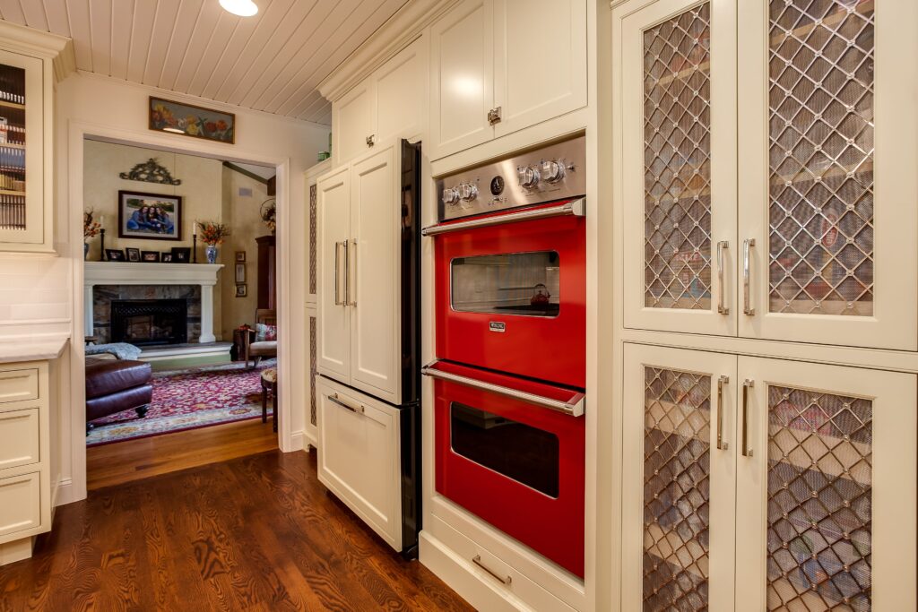 Red double ovens in this white painted kitchen remodel in Cherry Hills